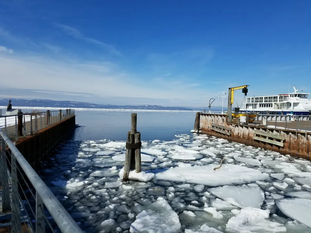 Winter, the worst time to visit Martha's Vineyard, pictured with ice chunks on the harbor water next to a ferry