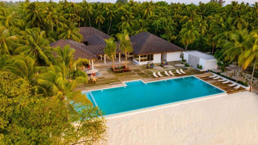 Fiyavalhu Resort pictured from the air with a beachfront bungalow for a piece on the best resorts in the Maldives