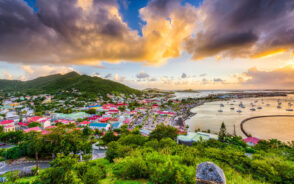 Hilltop view of Marigot in St. Martin on a gorgeous evening with an orange and yellow sky for a piece on the best time to visit St. Martin