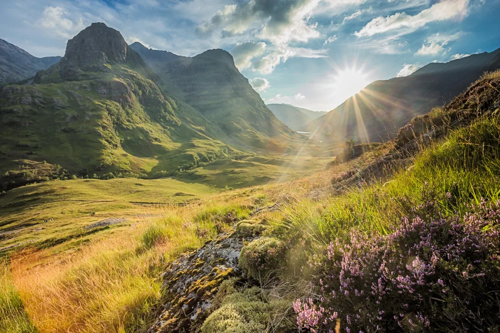 Sun beaming through the rolling hills in Glencoe, one of the best places to visit in Scotland