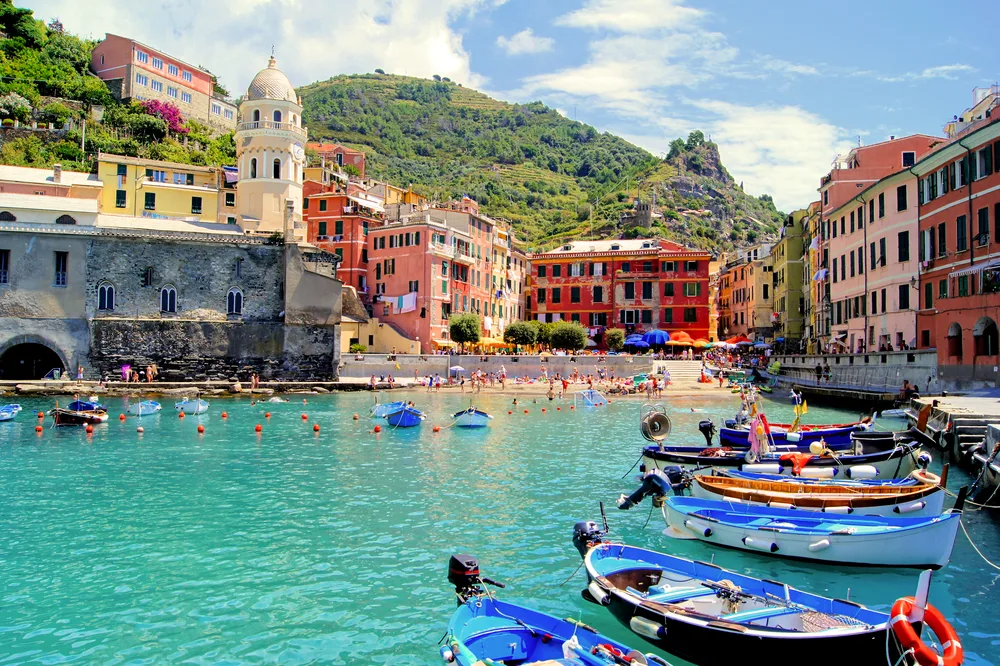 Harbor with colorful buildings and boats floating on the water at Cinque Terre, one of the best day trips from Rome