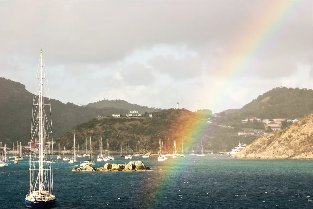 Rainbow over St. Barts with lots of sailboats on the harbor