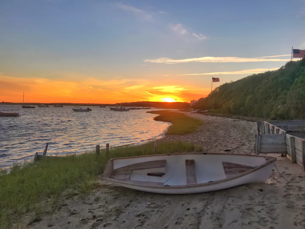 Old row boat on the sand at sunset in Chatham for a piece titled Is Cape Cod Safe to Visit