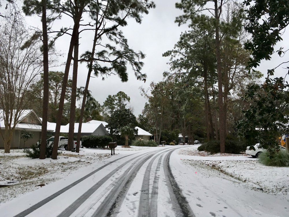 Snow on a residential street during the cheapest time to visit Hilton Head, the winter