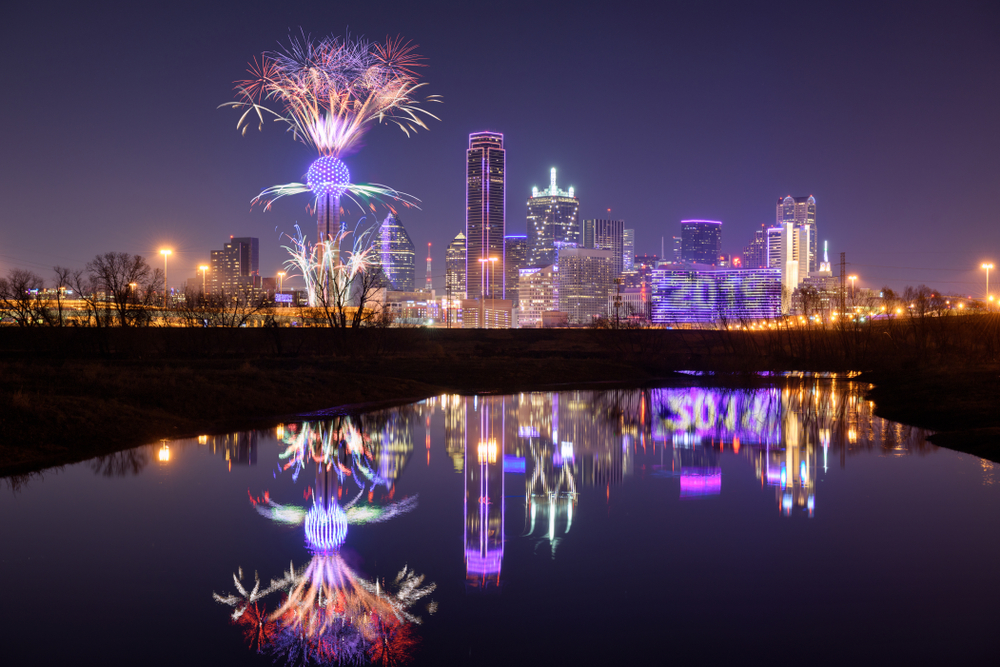 Fireworks over reunion tower pictured at night above the cityscape during the winter, the overall cheapest time to visit Dallas