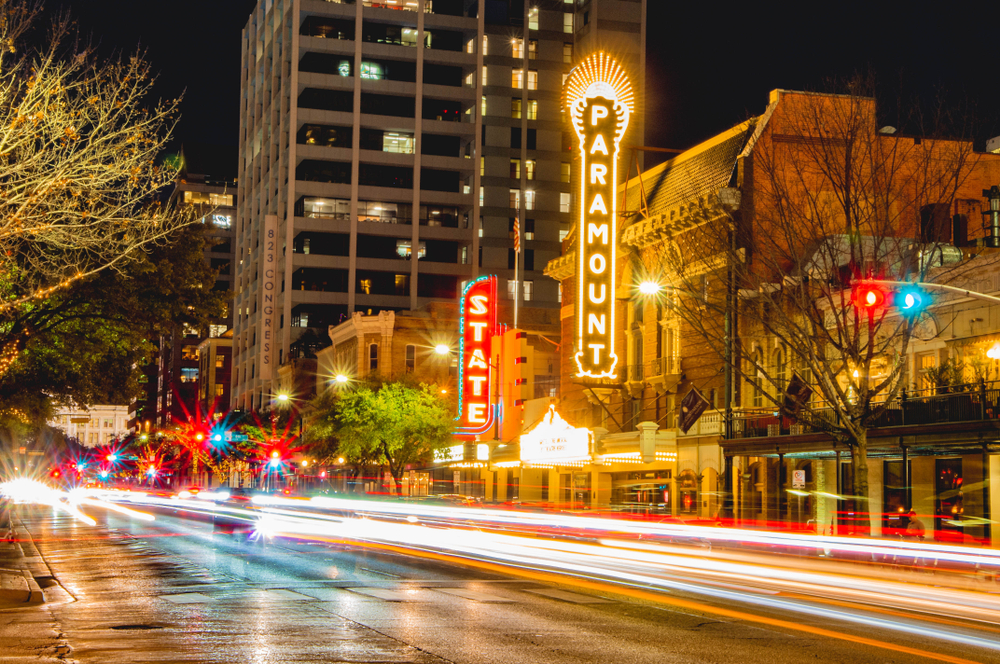 Long exposure image of cars driving around in Austin outside of the Paramount and State theatres, pictured during the best time to visit Texas