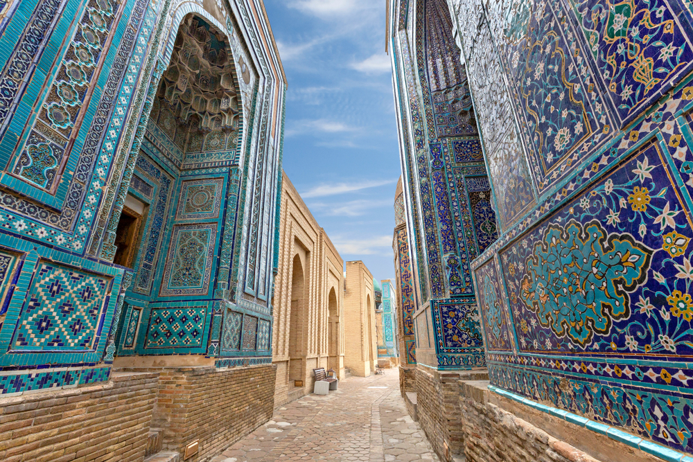 Historical necropolis of Skakhi Zinda in Samarkand pictured with blue walls lining the stone street during the least busy time to visit Uzbekistan
