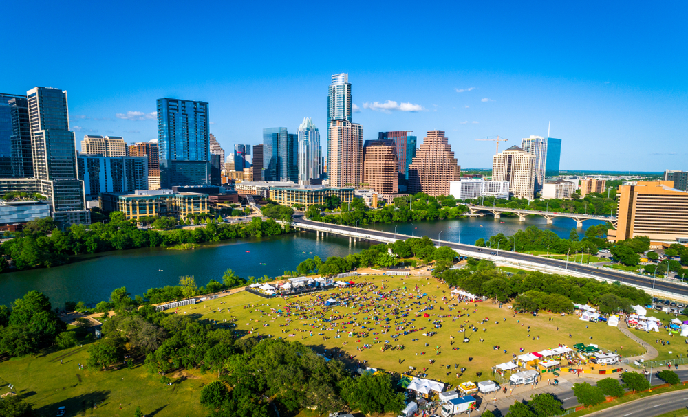 Aerial drone shot of a park in Austin with a heavy crowd and high temps during the worst time to visit Texas