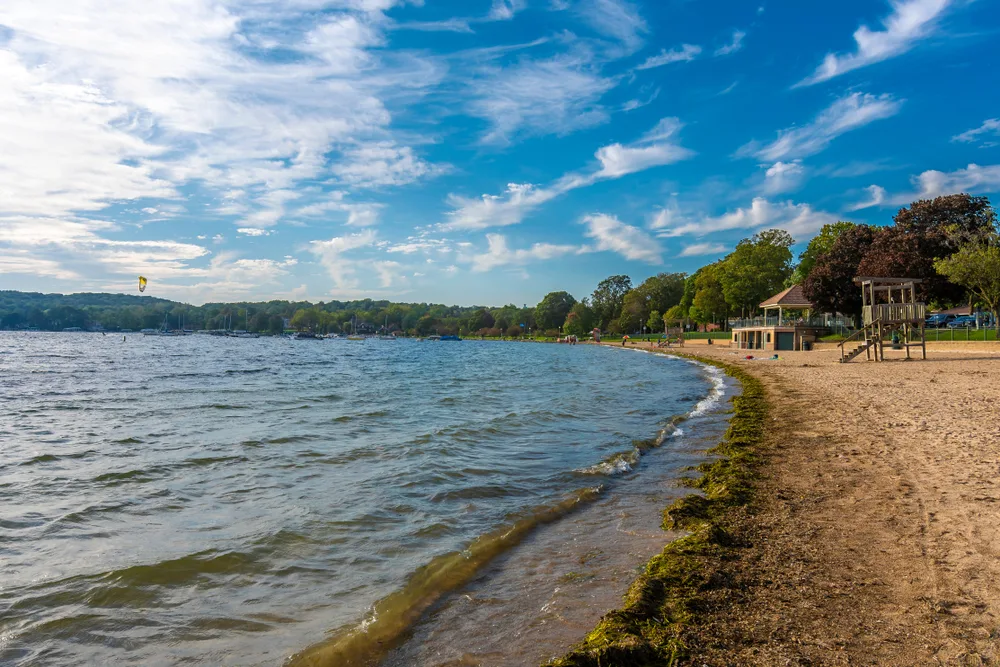 Lake Geneva in Wisconsin, one of the best day trips from Chicago, pictured on a blue-sky day with a kitesurfer off in the distance on the left