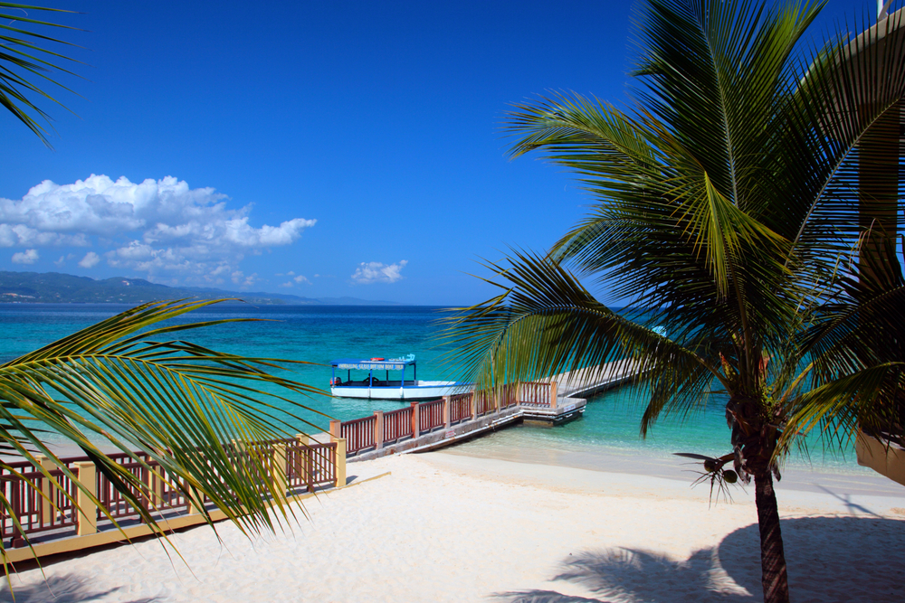 Gorgeous view on a blue sky day of a boat and dock pictured during the best overall time to go to Montego Bay