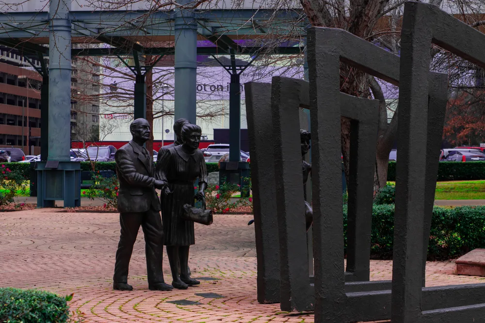 Statues and monuments pictured with glass office buildings in the back