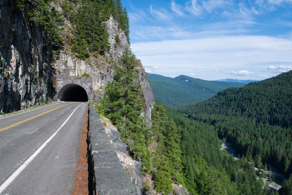 Road on the side of a mountain with a tunnel going into the rock during the best time to visit Mount Rainier