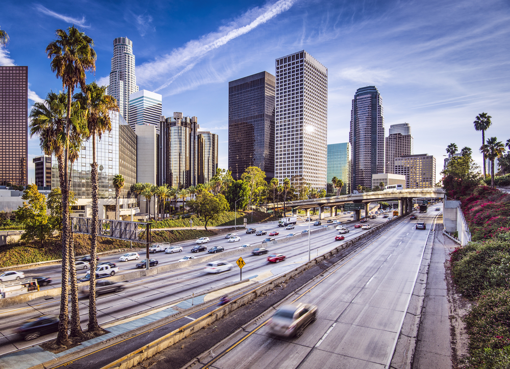 Downtown Los Angeles pictured in a low-exposure image with blurry cars and skyscrapers towering over the highway