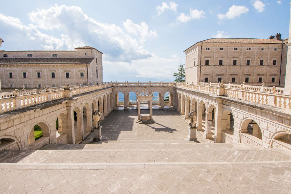 Cloister and balcony of the Montecassino Abbey, one of the best day trips from Rome, pictured on a semi-sunny day overlooking the ocean