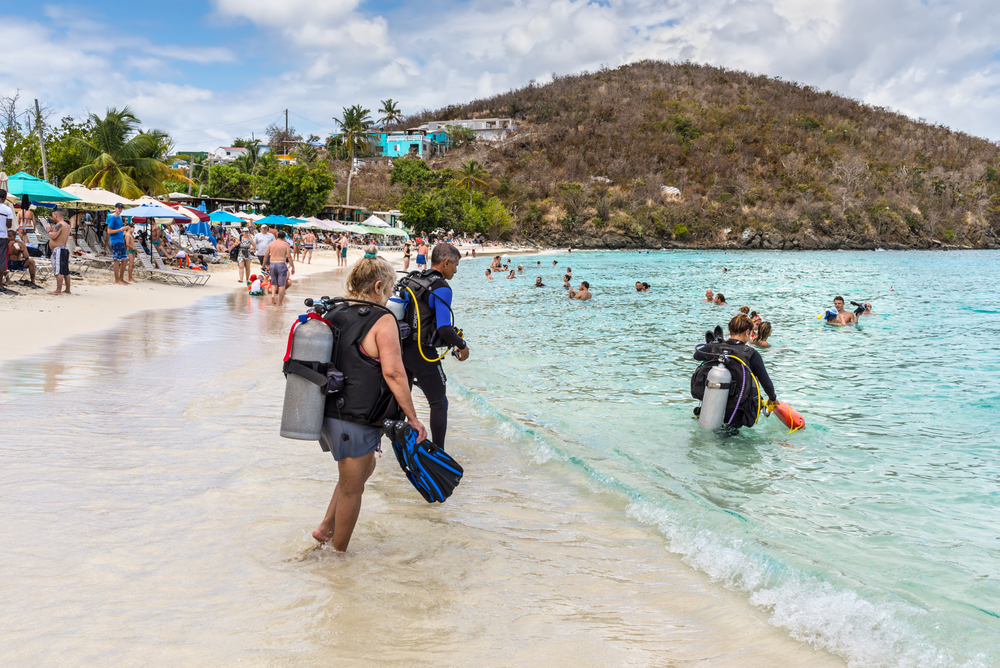 Busy beach in the USVI at St. Thomas pictured with lots of people scuba diving and walking in the water