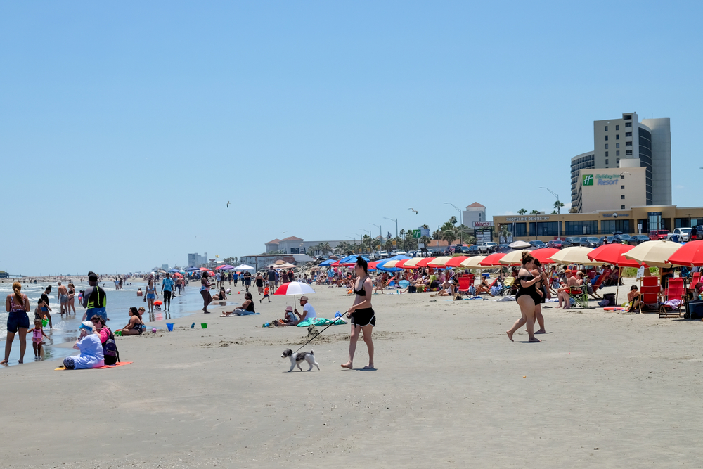 Image of a crowded beach in Galveston with lots of people on it for a piece on the worst time to visit Galveston TX