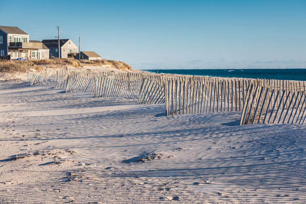 Photo of the gorgeous white sand Madaket beach with a wooden dune fence running along the length of the beach