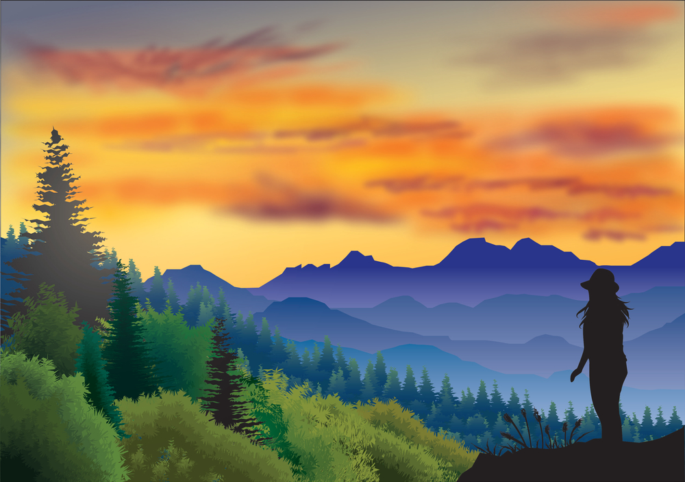 Woman standing in the Smoky Mountains with a gorgeous sunset behind the mountain and an orange sky with her figure in a shadow-style image