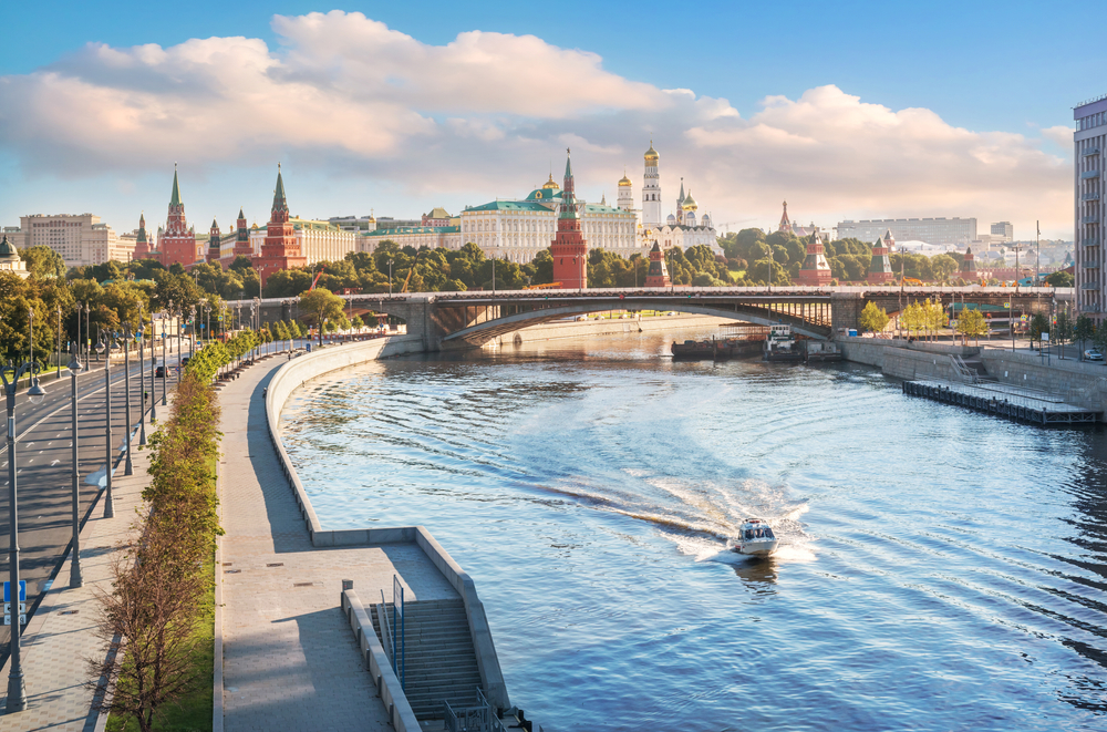 Aerial view of the Moskova River and the Kremlin, as seen from behind the Patriarchal Bridge with a boat driving along the river during the best time to visit Moscow