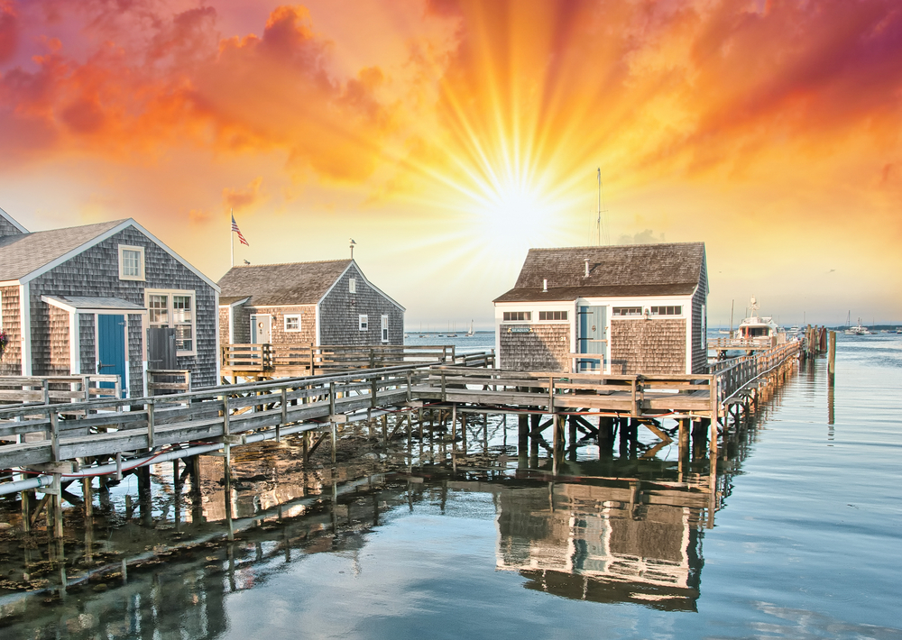 Beautiful sunrise over small wooden homes on stilts in the harbor during the best time to visit Nantucket