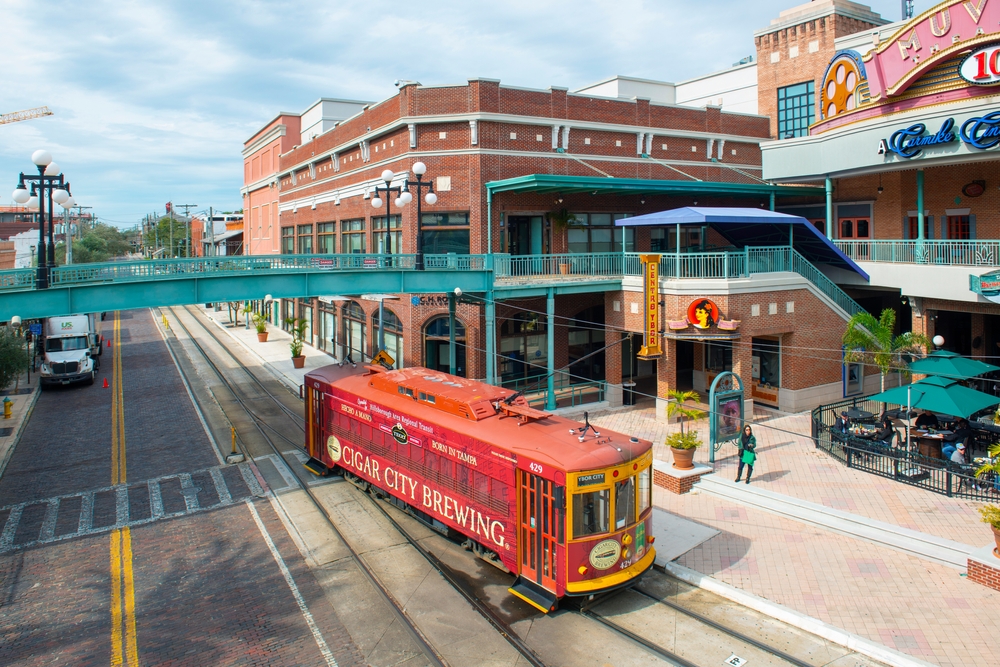 Streetcar in downtown Tampa pictured from the balcony of a building with clear skies in the background