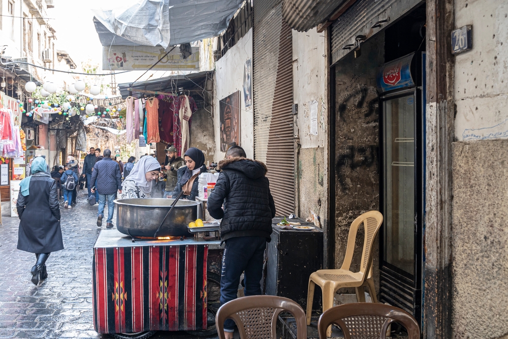 Old town Damascus pictured with street vendors selling food to people walking along the stone streets for a piece on is Syria safe to visit