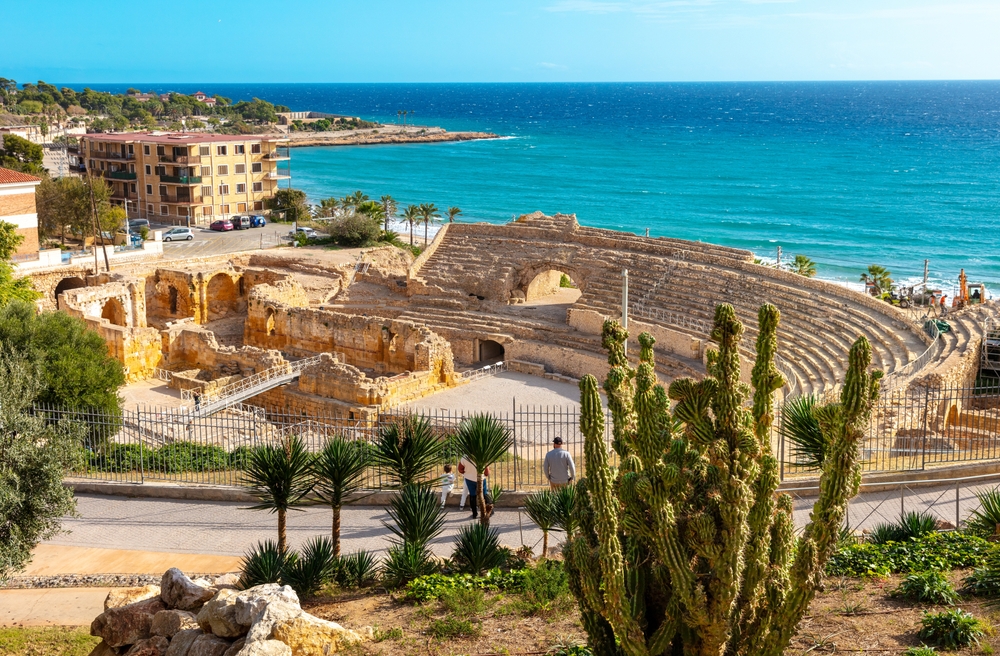 Neat aerial view of the Tarragona, one of the best day trips from Barcelona, on a sunny day with the ampitheatre overlooking the blue water of the ocean