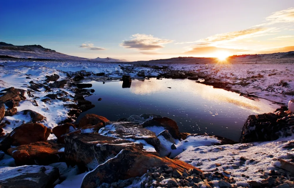 Moody Brook pictured with the sun setting over the hills with snow-capped rocks all around pictured during the least busy time to visit the Falklands
