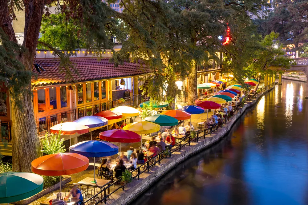 San Antonio canal pictured during the best time to visit Texas with umbrellas along the canal