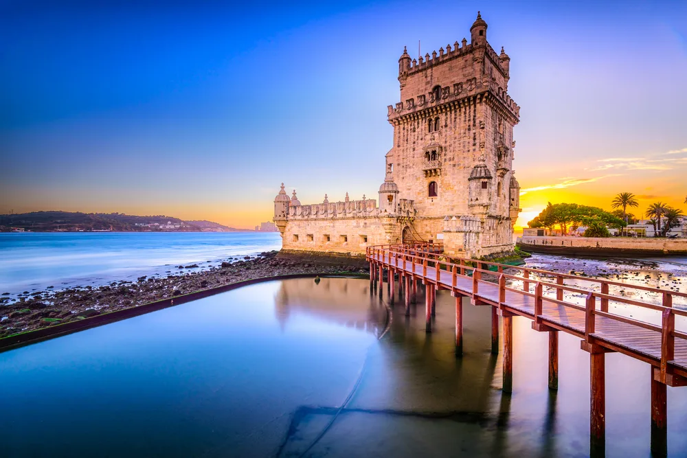 The Belem Tower on the Tagus River pictured overlooking the still water at dusk during the best time to plan a trip to Lisbon