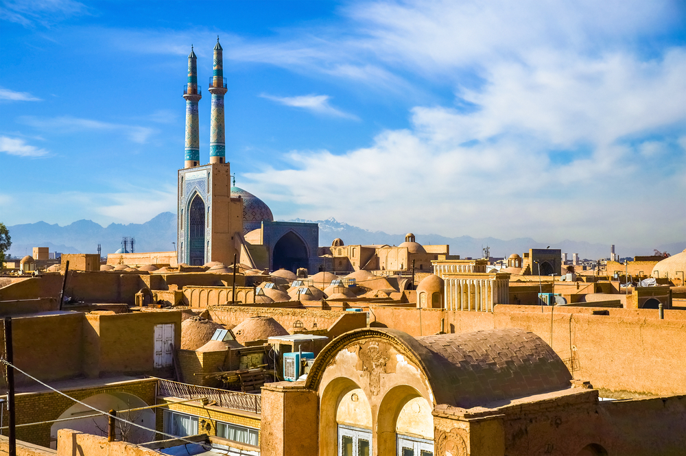 Historic ruins at Yazd pictured on a clear day with mountains in the background