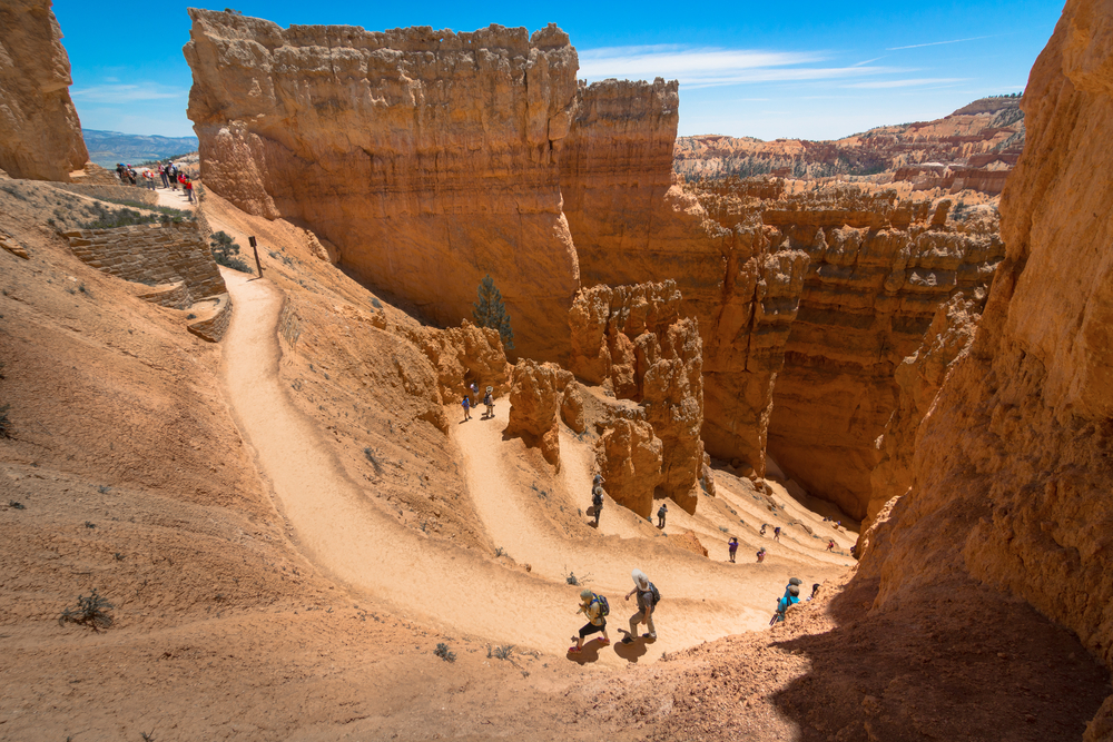 People walking along the dirt trails that wind through the rock formations during the best time to go to Bryce Canyon National Park