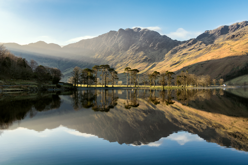 Gorgeous morning on Buttermere in Lake District, one of the best places to visit in the UK, pictured on a clear day with a bit of fog on the horizon