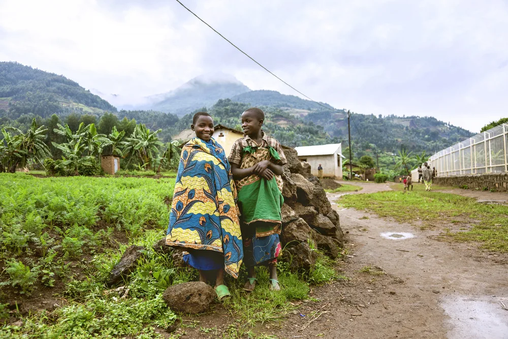 Two kids wrapped in blankets pictured on a rainy day during the worst time to visit Rwanda