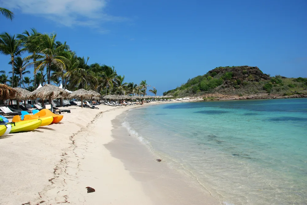 Colorful plastic kayaks pictured on the sand in St. Barts during the cheapest time to visit