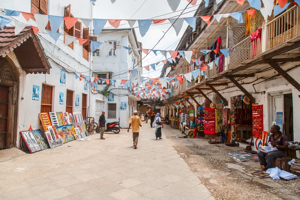 Stone Town in Zanzibar pictured during the best time to visit with an open-air market with people walking around