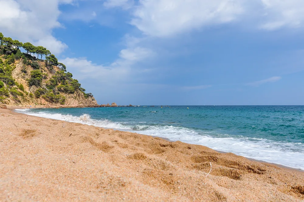 Platja Fonda beach pictured from the sandy beach looking out toward the water