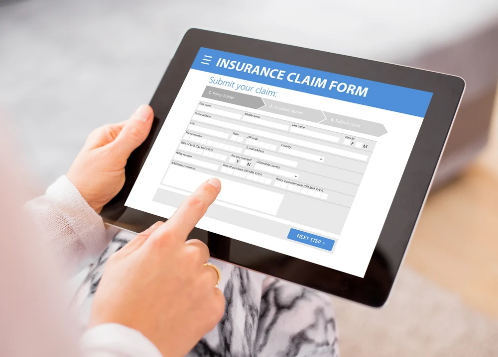 Person accesses a travel insurance claim form online with a tablet to show how travel insurance works