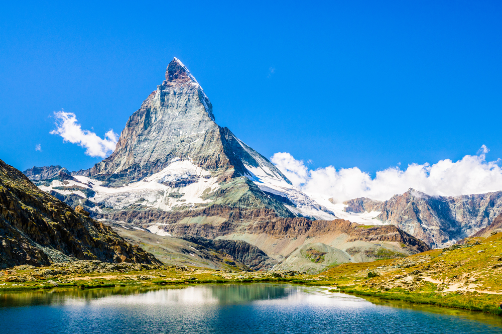 Stunning view of the giant Matterhorn pictured towering above the lake and green valley below in one of the best places to visit in Switzerland