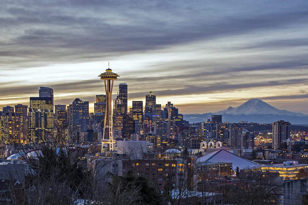 Gorgeous winter view of Seattle with Mount Rainier in the background pictured for a piece on the best places to visit in the Winter in the USA