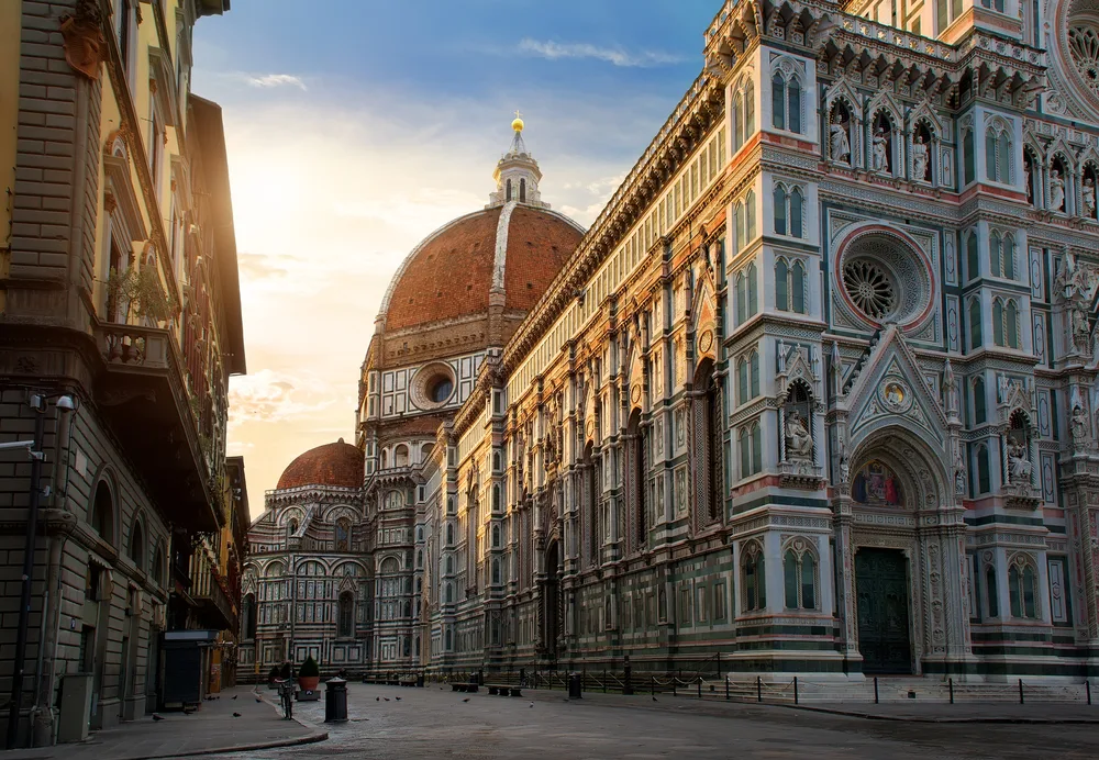 Piazza del Duomo pictured from a narrow alleyway at dusk in Florence, one of the best day trips from Rome