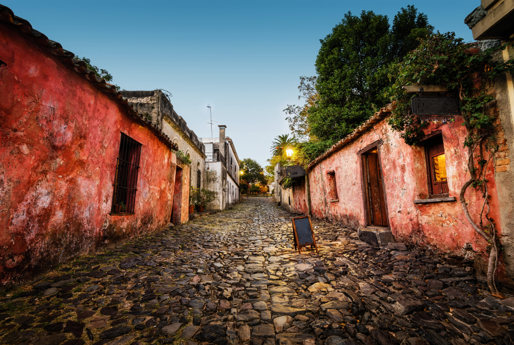 The Colonia del Sacramento with gorgeous red stucco walls and a stone path in the middle pictured during the least busy time to visit Uruguay with nobody around
