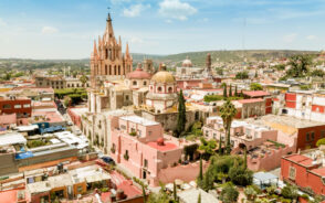 Aerial image of the town of San Miguel de Allende pictured during the best time to visit, with clear skies and mostly tan buildings