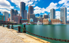 Cityscape in the downtown area pictured from the walkway next to the harbor for a piece on the best day trips from Boston to take