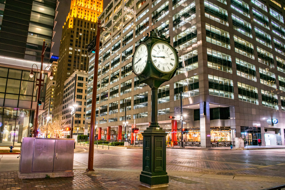 Historic city clock intersection with towering parking lots above for a piece on the best time to go to Houston