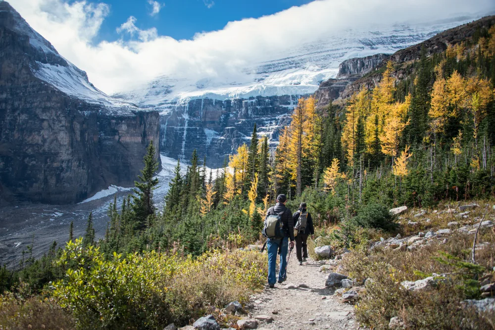 Two young tourists hiking the rocky path leading to Lake Louise in Banff, one of the best places to visit in September