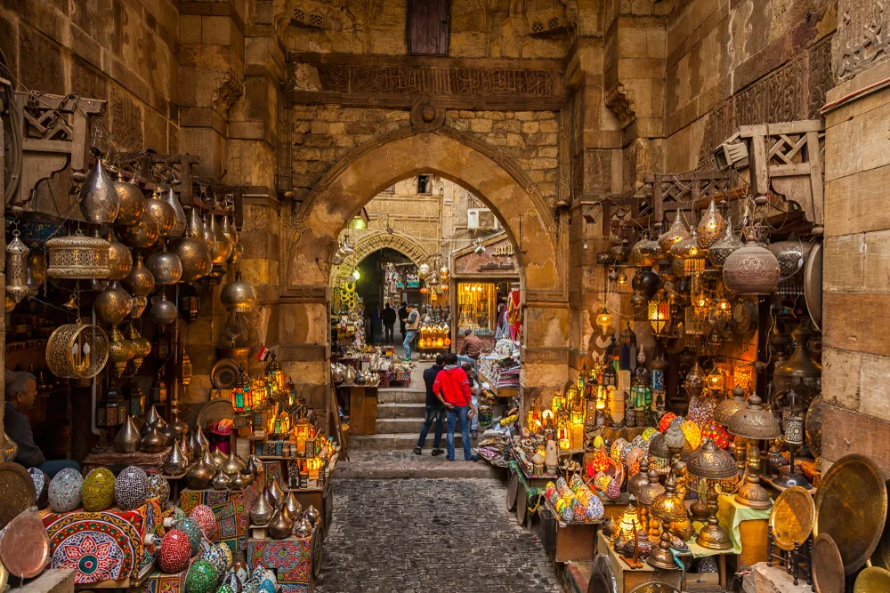 People milling about in an open-air market with handmade wares on either side for a piece on the best time to visit Cairo