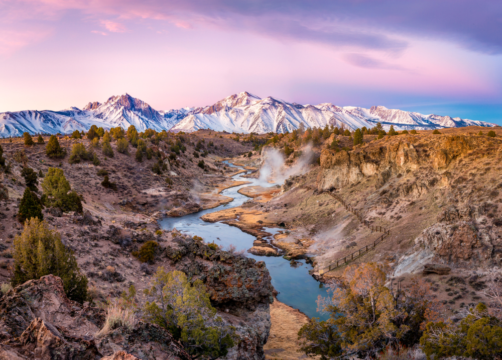 Sun rising over the Mammoth Lakes during the fall, the overall best time to visit, pictured with a hot spring with stairs going down to it