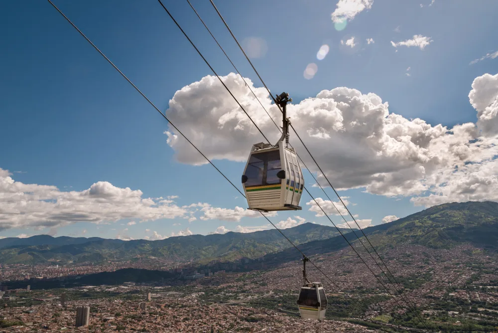Cable car traveling high over the valley in Medellin with countless homes below