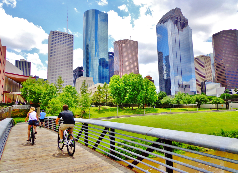 Cyclists crossing the bridge on a wooden path in downtown Houston, one of our favorite places to visit in Texas
